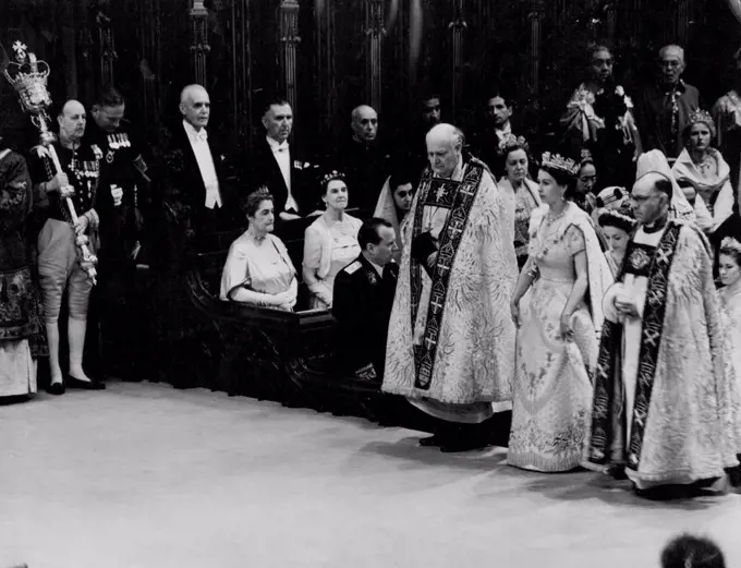 Coronation: The Queen In The Abbey The Queen during her progress through Westminster Abbey after her arrival for the Coronation ceremony to-day (Tuesday). On either side of the Queen are the Bishop of Durham, the Rt. Rev. Arthur Michael Ramsay (left) and the Bishop of Bath and Wells, the Rt. Rev. Harold William Bradfield. The Queen is wearing her Royal robe of crimson velvet, trimmed with ***** and bordered with gold lace. On her head, she has a diadem of precious stones. The Queen is also wearing the collar of the Garter. June 2, 1953. (Photo by Reuterphoto).
