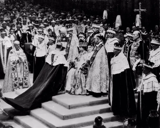Duke Pays Homage To His Wife, The Queen - The Duke of Edinburgh kneels before the throne and pays hoamge to his wife Queen Elizabeth II, in Westminster Abbey after her coronation yesterday. Churchman at left, holding book, is the Archbishop of Canterbury. Flanking the Queen are the Bishop of Durham, left, and the Bishop of Bath and Wells. Others surrounding throne are unidentified peers and churchmen. June 03, 1953. (AP Wirephoto).