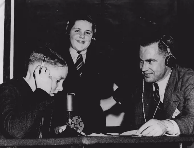 During the war the ABC was responsible for sending messages to Australian servicemen overseas and to the relatives of British children who had been evacuated to Australia to escape the German blitzkrieg. Here Jim Pratt helps two boys with the technicalities of a two-way radio-telephone conversation with their parents in England. January 1, 1941.