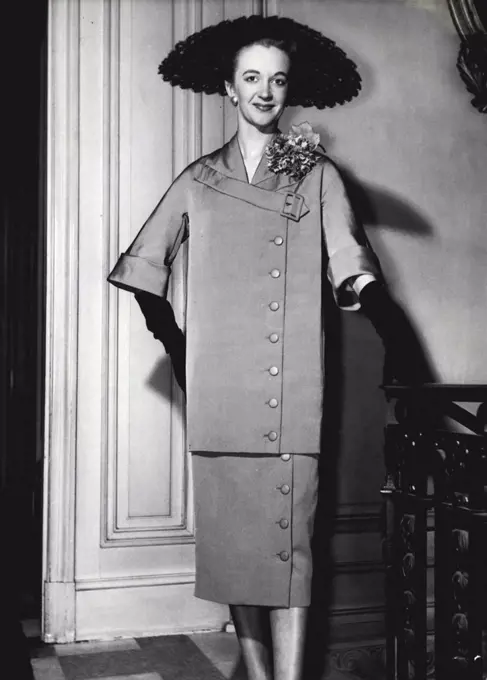The straight look in Worth's cocktail suit in copper coloured faille -- a long straight jacket worn over a long waisted dress. February 01, 1955.