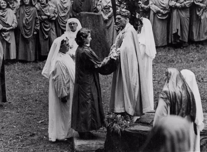 Princess Elizabeth Invested As A Bard -- The Princess receives her Gorsedd title from the Archdruid placing her hands between his. H.R.H. Princess Elizabeth was this morning invested as Honorary Ovate of the Gorsedd of the Bards of Wales, at a ceremony at Mountain Ash. Glamorgan, under the title 'Elizabeth of Windsor'. August 06, 1946. (Photo by United Kingdom Information Office).