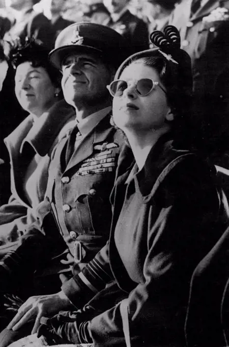 Princess Elizabeth Visits The R.A.F. - Princess Elizabeth - with Air Marshal Sir Basil Embry, Air Officer Commanding-in-chief, Fighter Command - Wears sun-glasses as she watches a demonstration of aerial acrobatics and high-speed flying, during a visit to the headquarters of the Royal Air Force Fighter Command, at *****, Middlesex. The Princess is wearing the "Winge" of the R.A.F. as a brooch on her hat. November 18, 1950.