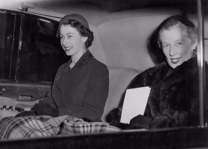 Queen Sees Coronation Paintings -- A blanket wrapped around her, the Queen smiles happily as she drives back to Buckingham Palace after visiting the exhibition of Coronation paintings and drawings on view in the Government offices in Whitehall Gardens, London. When the exhibition closes the pictures are to be sent to British Embassies and Consulates abroad. November 05, 1953.