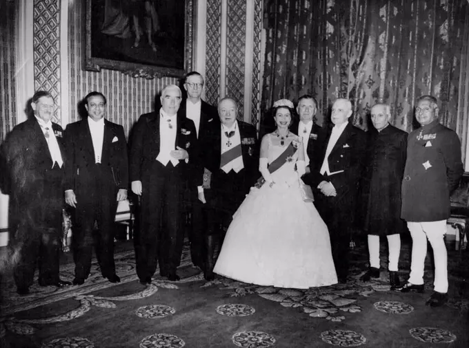 The Commonwealth Family -- Queen Elizabeth, happy head of the commonwealth and lovely in a Crinoline dress of white lace, is pictured her with the commonwealth Prime Ministers when she entertained them to dinner at Buckingham Palace, London, this evening February 2. The Ministers are in London for the commonwealth talks. From Left to Right are; Sir Godfrey Huggins (Central Africa Federation): Mr. Mohammed Ali (Pakistan): Mr. Robert Menzies (Australia): Mr. Charles Swart (South Africa's Minister of Justice who is representing his Prime Minister): Sir Winston Churchill: Mr. Sidney Holland (New Zealand): Mr. Louis St. Laurent (Canada): Pundit Jawaharlal Nehru (India): Sir John Kotelawala (Ceylon). February 10, 1955. (Photo by Associated Press Photo).