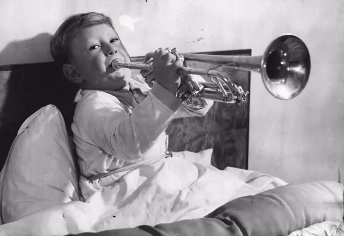 Young Man With A Horn -- A puffy-cheeked young man with a £22 silver trumpet may some day be the successor of Louis Armstrong and Harry James. 
He is 4-year-old Roger, son of Mr. and Mrs. Thomas Sawell of West Wickham, Kent -- pictured here in his bed, blowing high hard 'early morning' notes on his shiny instrument, as he does every morning at six o'clock. Mr. and Mrs. Sawell don't find it necessary to set their alarm clock. 
Roger has been blowing the trumpet since he was two years old, and his music teacher, Mr. E.G. Moss, ***** he can already play nearly as ***** as most youths of twenty. November 30, 1949. (Photo by Reuterphoto). 