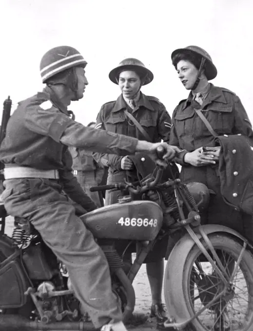 First A.T.S. Arrive in Normandy - Lance Corporal E. Martin A. Military Policeman talking to Corporal Joyce Collins of Norwich and Lance Corporal Cella Strong of Plumstead. Both these girls will act as M.P.'s in Normandy. The first party of A.T.S., have just arrived in Normandy, they will be attached to 21st., Army Group. Their duties will be to act as clerks in the beachhead. These pictures show the first party of 24 arriving by landing craft at one of the Normandy beaches. October 23, 1944. 