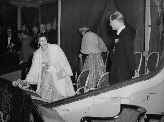 A Smile For The Duke -- The fur-coated Queen Elizabeth the second, turns with a smile of encouragement for the Duke of Edinburgh, right, as they arrive in the Royal box at London's Royal Albert Hall tonight for a concert in aid of British and Nether lands flood relief funds. March 04, 1953. (Photo by Reuterphoto).