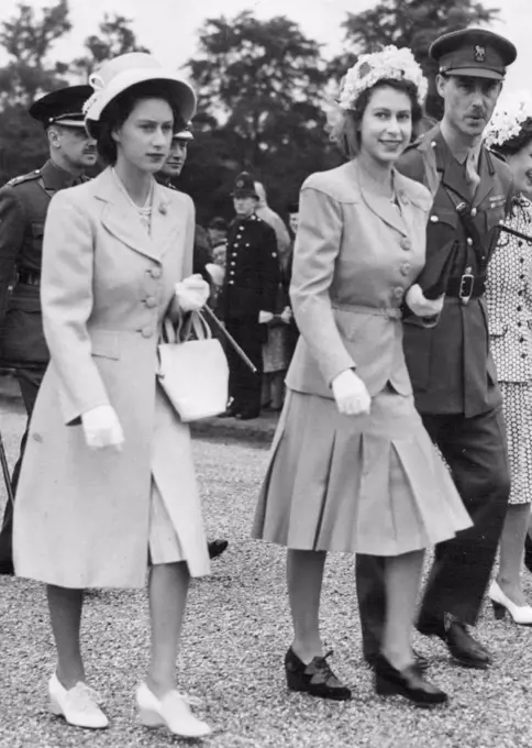 Royal Family Visits Sandhurst : King Presents New Colours To College. Princess Elizabeth, wearing a floral hat (right) with Princess Margaret Rose (left) wearing an off-the-race hat with a full length coat, arrive to watch the King present new colours to the Royal Military Academy, at Sandhurst. June 14, 1947.