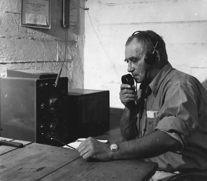 Kruger Nat. Park - There being no telephone in the Park, all sectors are connected by radio to headquarters at Skukuza. At seven each morning, Col. Sandenbergh, the Chief Warden, checks with all rangers throughout the Park. Here Ranger Hector MacDonald is seen reporting to the Chief Warden from his office at Crocodile Bridge. November 25, 1948. (Photo by George Rodger, Magnum).