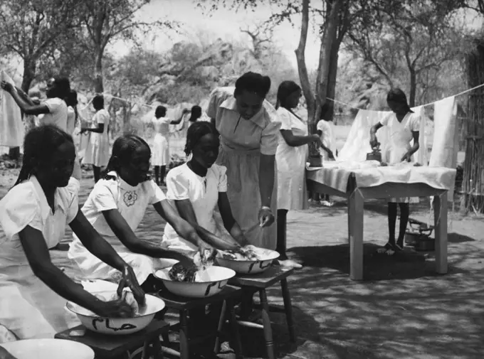 Sudanese Girls Train To Be Teachers.
They Learn In Grass Hut Classrooms Until New College Is Ready.
Each girl has her own washbasin marked with her own name. May 14, 1953. (Photo by Central Office Of Information).