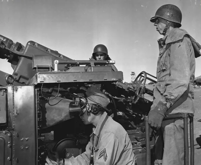 Look To The Skies -- Radar operator Cpl. Joseph E. Brunner, Onaga, Kansas, Adjusts his radar scope device as cannoneers Pfc. Eugene E. Keeney and Pvt. Gene E. Ball, Frederick town, Missouri, stand by for action. They are members of battery a, 531st anti aircraft artillery Bn., Fort Bliss, Texas. December 06, 1954. (Photo by Official U.S. Army Photo).