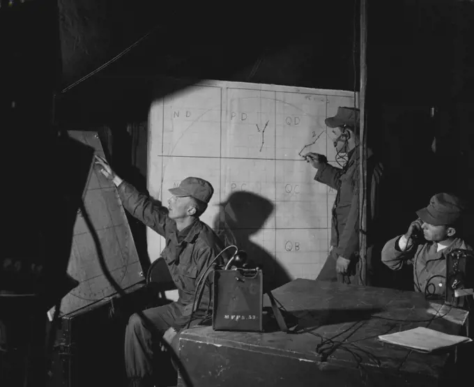 Look To The Skies -- Men of battery a, 531st anti aircraft artillery battalion, Fort Bliss, Texas, compute information received from an operations center preparatory to firing the skysweeper at an oncoming target. Show left to right are: Cpl. Floyd W. Hyronimouos, Conversion Plotter, from Davis, South Dakota; Pfc. George R. Pollet, Radar Plotter, from Dewey, Oklahoma and 1st. Lt. David B. Smith, battery operations officer, from El Paso, Texas. December 06, 1954. (Photo by Official U.S. Army Photo).