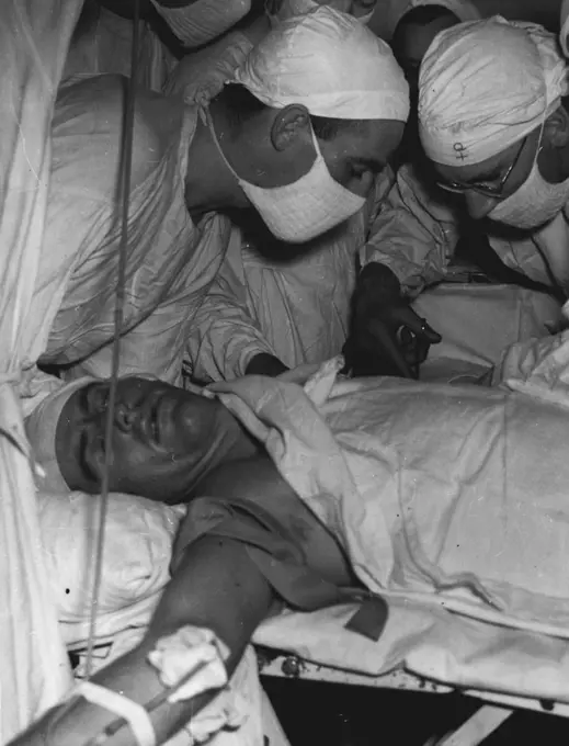 Australian, American and Dutch servicemen wounded during the recent Tarakan landing are in the hands of some of Australia's outstanding surgeons at an Australian General Hospital in the Dutch West Indies within hours of being wounded. Here a group of surgeons and nurses are concentrating on a delicate operation on the nerve of the upper arm of a patient. July 30, 1945. (Photo by Australian Official Photo).
