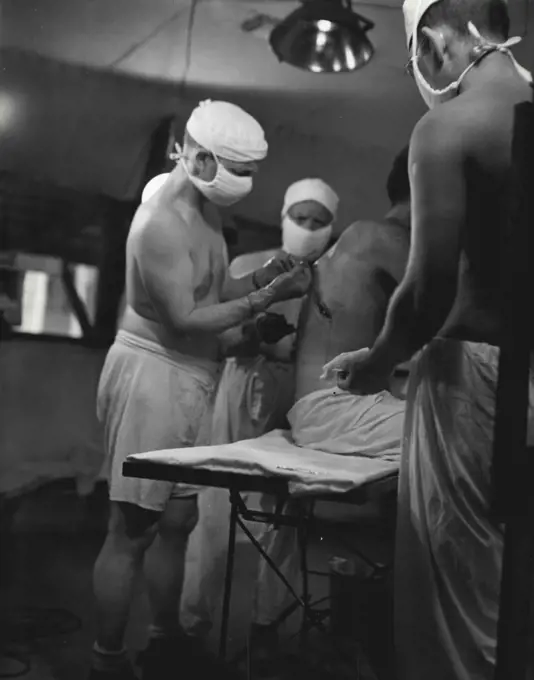 Medical Series: Inserting tube to drain wound. February 14, 1944. (Photo by Official U.S. Navy Photograph).