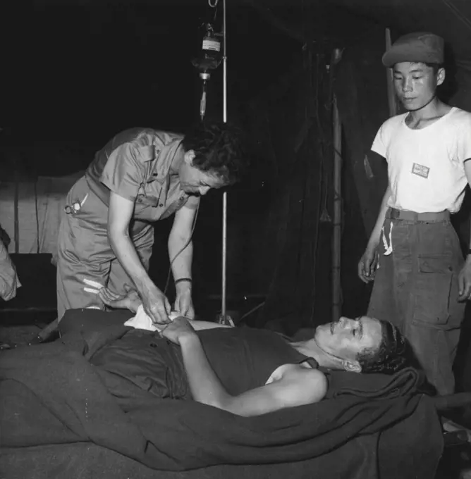 Helicopters Rush Wounded To Surgical Care -- An Army nurse gives a blood to a wounded United Nations soldier, as a South Korean stands by to assist. September 3, 1952. (Photo by United States Information Service).