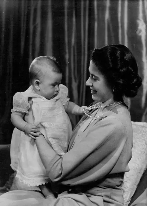 H.R.H. Princess Elizabeth And Prince Charles :First informal photograph of H.R.H. Princess Elizabeth at play with her infant son. The picture was taken in Princess Elizabeth's private sitting room at Buckingham Palace. Her Royal Highness is dressed in dove-grey. April 9, 1949. (Photo by Baron, Camera Press).