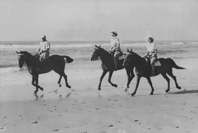 Princesses Ride On African Beach -- The Princess enjoyed an off-duty break from the Royal Tour of South Africa when they went riding on the golden sands of Bonza Beach, East London, Princess Elizabeth (centre) is riding Miss Yvonne Hayhoe's "Jill" while Princess Margaret rides "Treasure" owned by Mr. Pat O'Reilly. Mr. O'Reilly of East London, is seen escorting the Princesses. March 12, 1947.