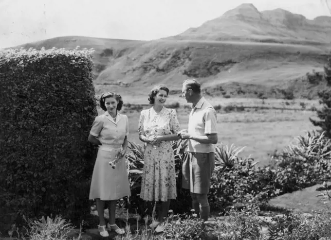The King And His Daughters On Holiday In Natal -- Princess Elizabeth smiles at the King in the *****  spaces of the Natal national Park. On left, ***** a flower, is Princess Margaret.The Crowded South African tour of the British Royal family was interrupted for four days while King George, Queen Elizabeth and their daughters, Princess Elizabeth and Margaret took a well-earned rest in the Natal national park, situated on the Natal-Basutoland border 60 miles south-west of Ladysmith. The Royal Party stayed in a thatchod hostel at the foot of the Drakensburg Mountains, from where they were able to take walks in the Drakensburg foothills.The Princess were also able to do some swimming. March 22, 1947.
