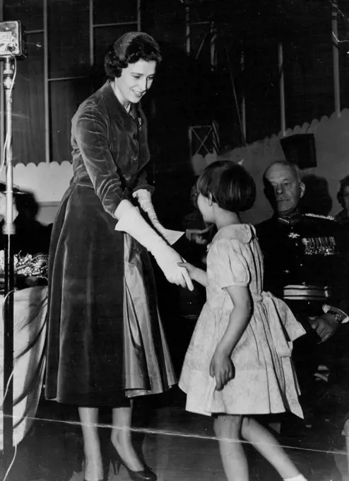 A Purse For the Princess - Six-year-old Wendy Aston shakes hands with Princess Alexandra after presenting her with a purse containing a contribution to the Benevolent and Orphan Fund of the National Union of Teachers, at Scarborough yesterday. Wendy, daughter of the secretary of the Walsall board of the Fund, was giving the Princess Walsall's donation; one of more than 400 purses containing a record total of $72,491. April 15, 1955. (Photo by Reuterphotos).