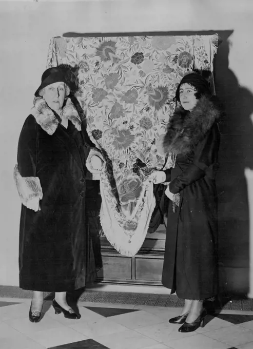 Duchess of York Opens Needlework Sale -- The Duchess of York (right) who is the president of the school with Princess Helena Victoria. Vice president with an exhibit. The Duchess of York accompanied by Princess Helena Victoria opened the Royal Needlework School's Sale at the Schools headquarters. January 01, 1931.
