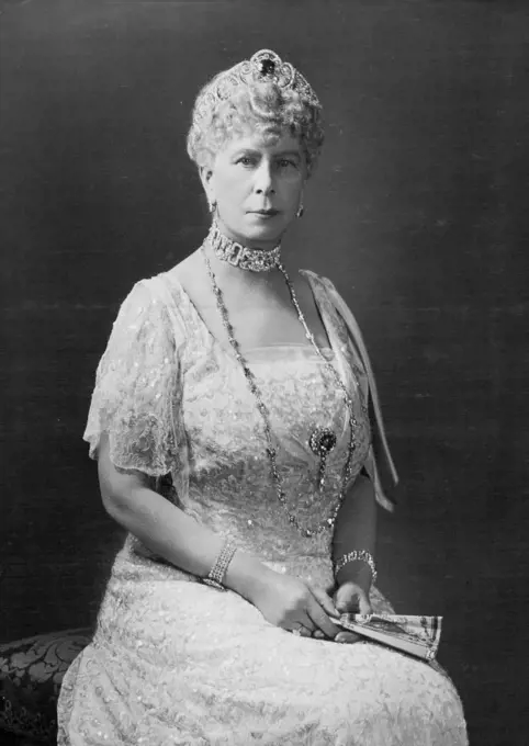A Beautiful Gracious Well Beloved Lady -- An Hitherto Unpublished Portrait Of Her Majesty Queen Mary Whose Birthday Is On May 26 -- Loving thoughts will go out towards our Queen on May 26th when she is 70 years of age in 1934. She is here seen wearing on of her favoured lace dresses ivory lace over an ice blue satin slip with ice blue satin bow from the shoulder. Also she is wearing some of her lovely sapphires and diamonds and carries a hand painted fan. Her Majesty has a beautiful collection of fans. Queen Mary wanted her 69th Birthday to pass without any special reminder of it, but King Edward and his brothers I understand, thought that the usual luncheon ay Buckingham Palace should take place. Practically all the grown up members of the Royal Family will be present. Princess Elizabeth will visit their grandmother during the day. February 08, 1937. (Photo by Hay Wrightson).
