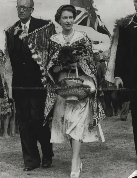 Gifts - Queen Elizabeth ***** charming and happy as she leaves a Maroi ceremony at Arawa Park, Rotorua, in a Maori chief's cloak. The Queen is carrying gifts of flowers and two baskets. January 07, 1954.