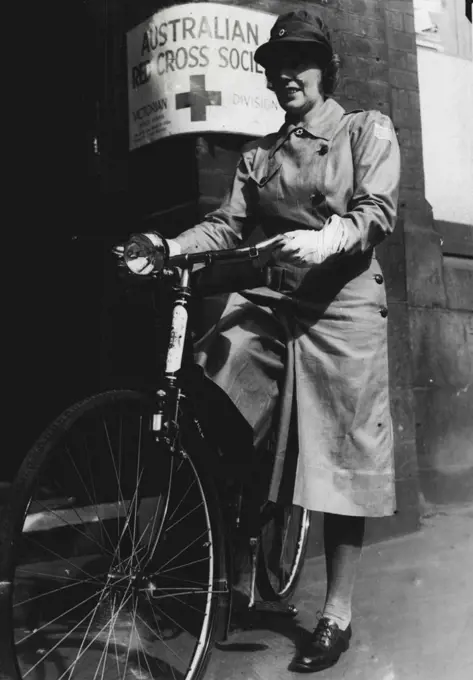 A uniformed Red Cross cycle service has been formed in Melbourne. Fifty girls, using their own cycles, will deliver messages, and will be used in time of emergency. Above: Miss D. Walsh leaving Red Cross house today. February 19, 1942.