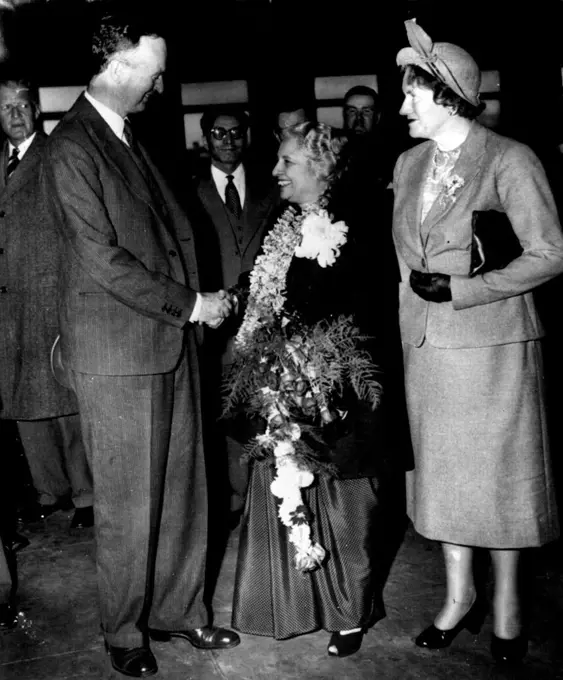 Goodbye To Madame Pandit - Madame Vijava Lakshmi Pandit, India's retiring ambassador, wears and carries farewell
flower gifts as she receives a goodbye and a handshake from Sir Oliver Franks, British ambassador, at Union station this evening. Mrs. Franks (right) is with them, John Simmons (left background, state department protocol chief, represented the U.S. as Mme. Pandit left for New York on her way home. She will become a candidate for parliament in India's first constitutional election. November 15, 1951. (Photo by AP Wirephoto).