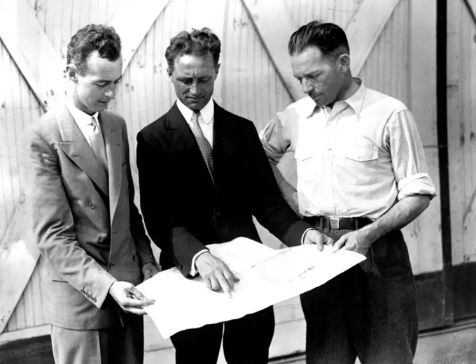 Planning To Beat Gatty-Post's Time-- Captain Harry Manning, center, of the S.S. American Trader, helping Hugh Herndon, left, and Clyde Pangborn map out their flight over the steamer lane which they will take instead of the great circle used by other flyers. They hope to circle the globe in six days clipping two days from the record just established by Harold Gatty and Wiley post. July 01, 1931. (Photo by International Newsreel Photo).