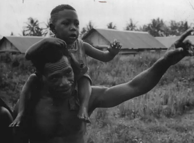 Papuan family wave to the Duke of Gloucester at Lae, New Guinea. July 9, 1945.