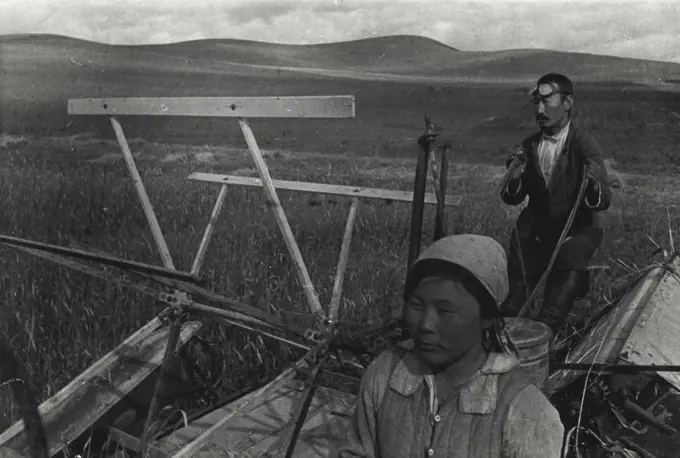 Harvesting Grain in Soviet Buryat-Mongolia (Eastern Siberia).
Collective farmers of Buryat-Mongolia operate a sheaf-binder in the harvest field.
The Buryat-Mongolian Autonomous Soviet Socialist Republic is located to the West of Lake Baikal in Eastern Siberia of the Soviet Union. Its vast territory reaches over 400,000 sq.km. Before the Great Proletarian Revolution it was a Tsarist colony, land of convict labor and exile. The oppressed people of Buryat-Mongolia did not even have their own schools. Now the country is developing its cultural and economic life. January 1, 1937. (Photo by Zelma).