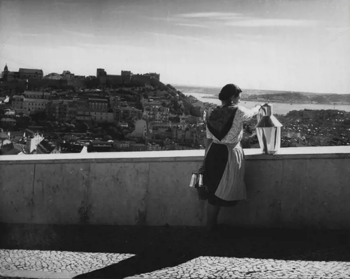 Lisbon 1952 -- One of Lisbon's most beautiful panoramas is the one of the castle of St. George and the Tagus River. The castle is a Moorish citadel which has been converted into a fort and barracks. In the foreground is a milk seller with her typical pewter jar. February 27, 1952. (Photo by Camera Press).