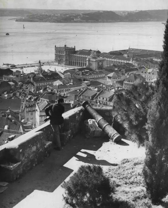 Cities of the World - Lisbon: This is a view of the expansive Tagus River from atop the ancient Fortress of St. George, with its copper cannons dating back to the 15th Century. Facing the river (at left) is Lisbon's Praza de Commerzio (Commercial Square). The Portuguese capital extends for about five miles along the Tagus, which brings in the ships from the Atlantic (nine miles away) and makes Lisbon one of the world's busiest ports. A city of contrasts, Lisbon boasts broad drives, fine squares, handsome bright-colored houses, modern transportation and other facilities, and excellent land scaping everywhere. April 22, 1955. (Photo by United Press).