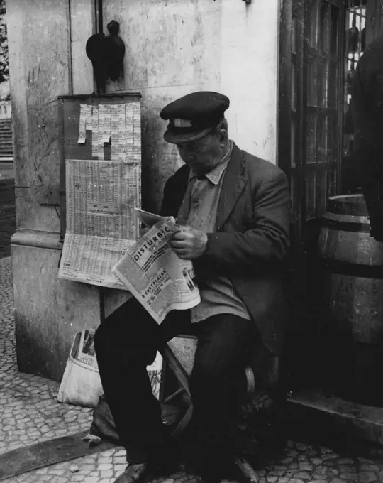 Lisbon 1952 -- A typical vendor of State lottery tickets reads his daily paper. February 27, 1952. (Photo by Sequiera, Camera Press).