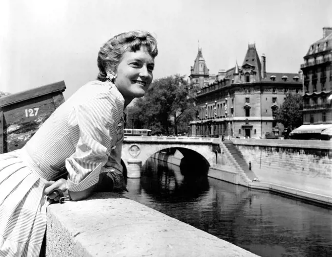 Oakes - Australia's champion, Beryl Penrose, who reached the quarterfinals of the French titles, loved the Seine quais, where one can lean and watch the river, admire the bridges and the old buildings and lift one's eyes to the Gothic towers of Notre Dame. June 21, 1955. (Photo by Michel Brodsky).