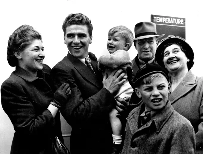 World amateur cycling champion, Sid Patterson, greeted in Melbourne by members of his family, on his return on the Himalaya. From left, Mrs. N. Weiss (sister), Sid, holding nephew Michael Weiss, Mr. and Mrs. Patterson (father and mother), and David (brother). November 5, 1949.