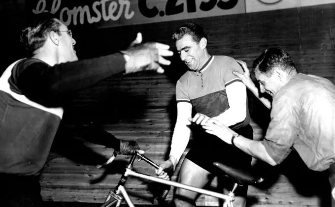 Sid Patterson (Centre) of Australian Jokingly "steals" a bicycle from Arie Van Vliet of Holland (left) during on of their off-Duty Periods in the six-day cycle race now running at Copenhagen, Denmark. Man at right is unidentified the race started December 8.
In an off-duty spot of clowning at Copenhagen Patterson pretended to steal a bike from Arie Van Vliet (left), his team mate. August 24, 1955. (Photo by Associated Press Photo).