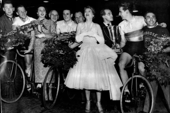 Australians win Six-Day Cycle Race:
Unidentified; Russell Mockridge (on cycle); Marie Berlioz, Vice Queen of the Race; Unidentified; Reginald Arnold (on cycle); Unidentified; Jacqueline Joubert, Queen of the race; French boxing champion Charles Humez; Sydney Patterson (holding Winners' cup, on Bike); Unidentified.
The Australian team after winning the six-day cycle race in Paris last night, March 9. They covered 4,132.5 kilometers at an average speed of 32.34 kilometers an hour (about 2,567.841 miles at an average speed of 20.085 miles an hour). They pulled up from 11th place in the last 24 hours, and took the lead only three hours from the finish. March 18, 1955. (Photo by Associated Press Photo).