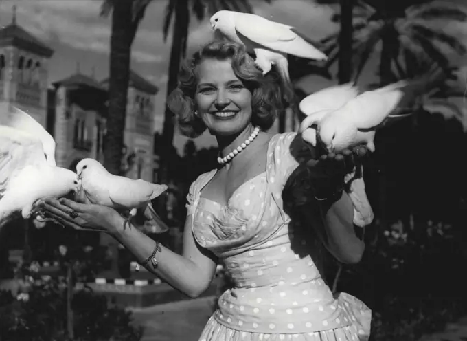 "Joan Finds Peace In Seville" -- In sunny Seville Joan found contentment - and she found these doves, the symbol of peace and a good omen for her future. 
December 19, 1955. (Photo by Sunday Mirror).