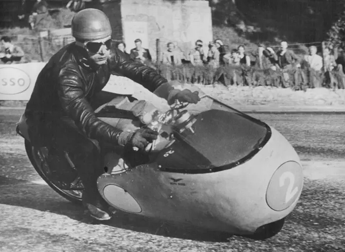 Italian Challenge in T.T. RacesDuillo Acostini, a member of the Italian Guzzi team, at speed on a Junior 350 ***** Guzzi during practice on the T.T. course on the Isle of Man in readlness for next week's races. June 3, 1955. (Photo by Central Press Photos).