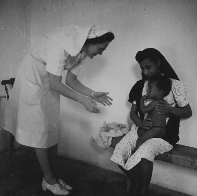 A bi-weekly baby clinic is held at the hospital. Sister Main Weighs and examines all the babies. September 19, 1951. (Photo by British Official Photograph).