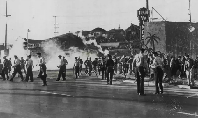 Crowd Runs As Tear Gas Let Loose -- A crowd of strikers and spectators breaksup as a tear gas bomb is let loose by police at the Standard Oil Co. refinery here today. AFL maintenance workers went through a picket line of C10 refinery workers setting off a two-hour fight between strikers and police. September 14, 1948. (Photo by AP Wirephoto)