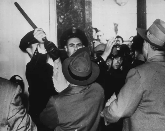 Police Officer Blocks Clubbing -- Oakland police officer grass club of special officer and cuts off attempt of special officer to swing his club as AFL unionists mass at downtown store in protest walk out here today. December 3, 1946. (Photo by AP Wirephoto).