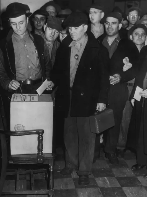 Ford Employees Take Strike Vote : Employees of the Ford Motor Co. Here, shown depositing ballots today, the last of the strike votes in the automobile industry's big three over a 30 per cent wage rate increase demand. Voters are members  of the United Auto Workers Union (CIO). November 7, 1945. (Photo by AP Wirephoto).