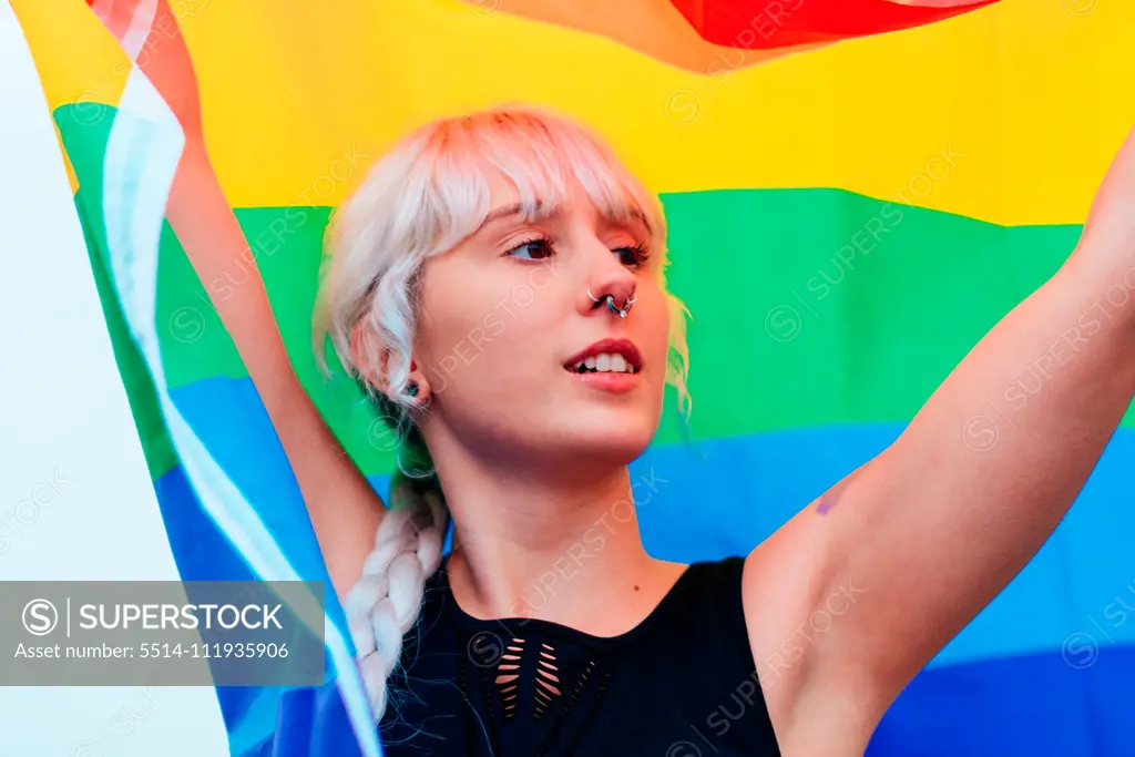 Lesbian woman with the flag of pride in sportswear at gay parade