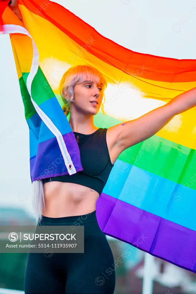 Woman waving rainbow flag at gay parade