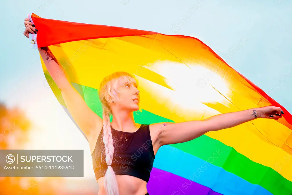 Lesbian woman with the flag of pride in sportswear