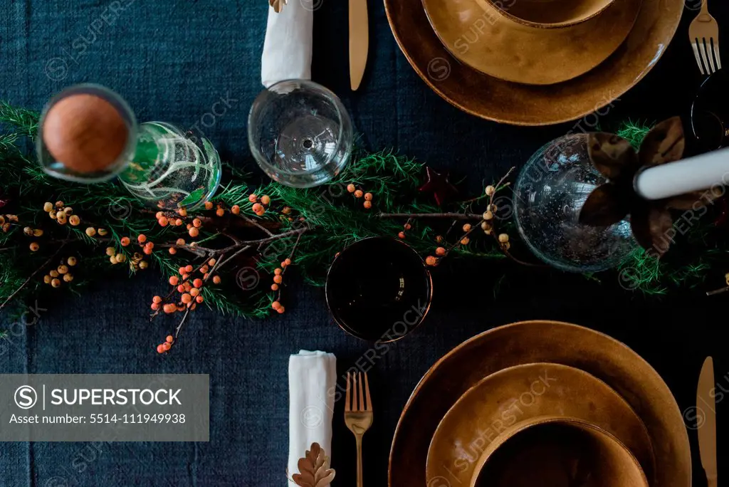 greenery and berries on a decorated dinner table