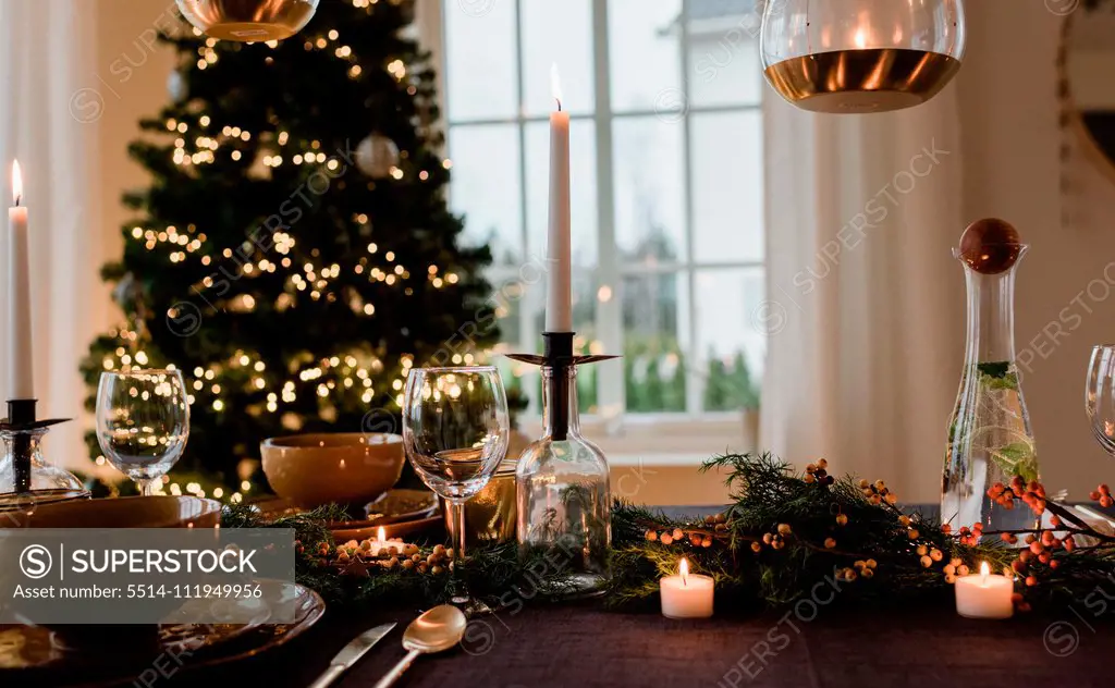 tall candle on a festively decorated dinner table at Christmas