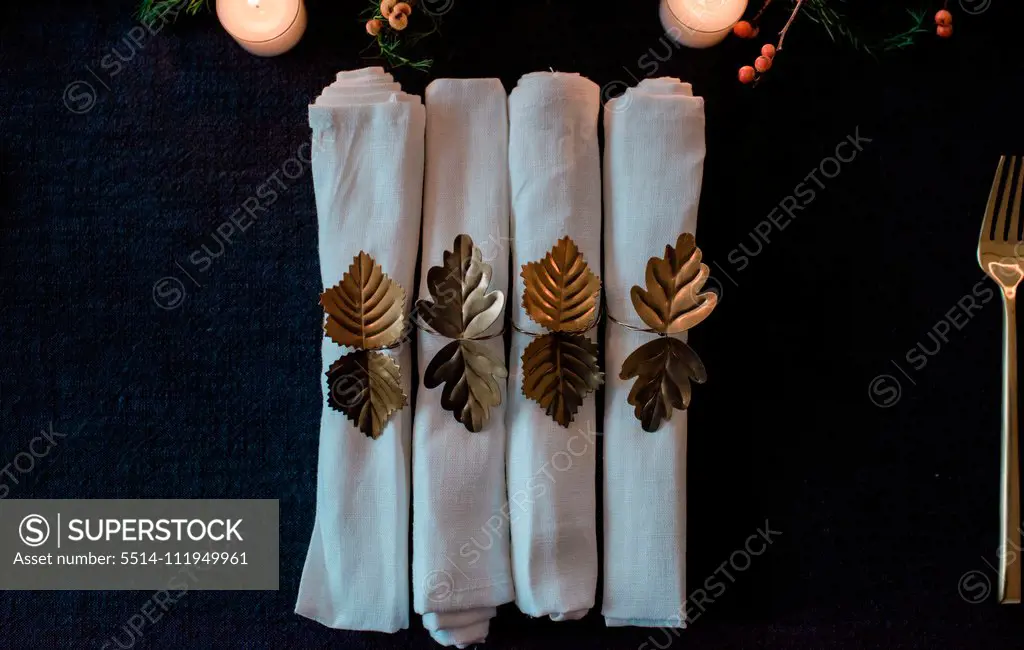 row of gold and white napkins on a decorated dinner table setting